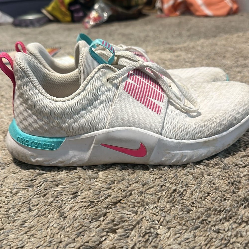 White and pink and blue women’s Nike renew running shoe